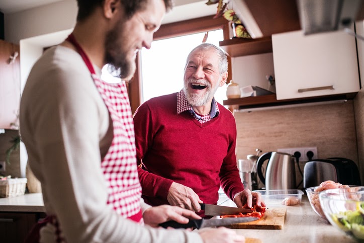 Adult son and elderly father cook together in the kitchen. Beneficiary rights in Massachusetts.